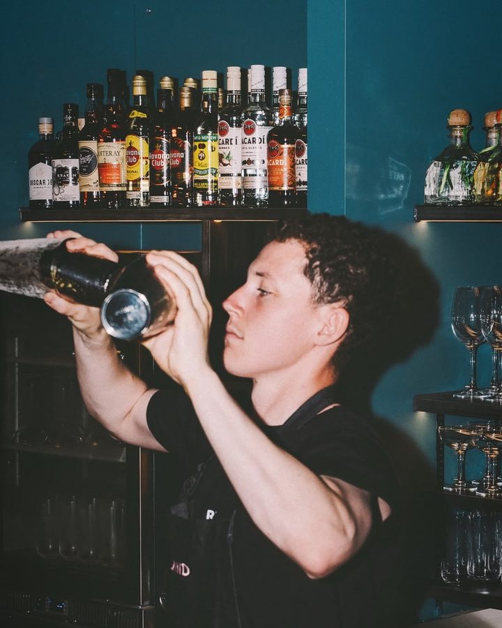 Sam Pyatt shaking a cocktail behind a bar
